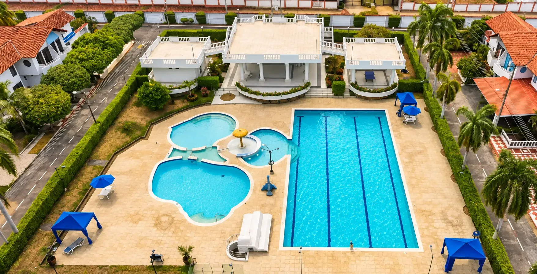 Vista aérea de la zona de piscinas del condominio: piscina semiolímpica de carriles y piscinas infantil y social